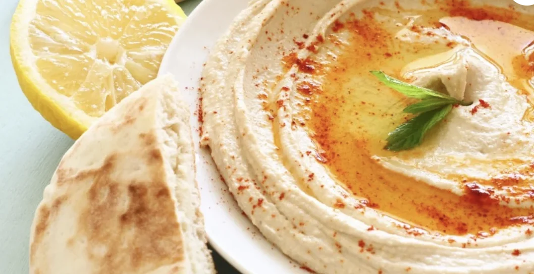 Hommos garni d’huile d’olive, d’épices, de menthe et accompagné de pain